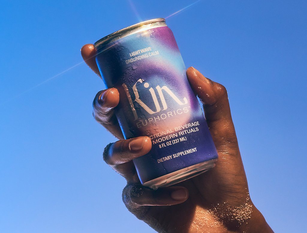 Hand holding a can of kin euphorics calming beverage, made with 0% ABV and functional ingredients 