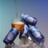 Multiple cans stacked of kin euphorics non-alcoholic calming beverage lightwave with one glass cup stacked on top of ice and crystals with liquid being poured in Thumb