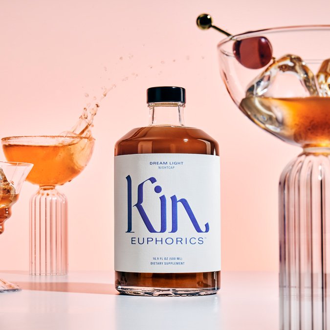 a bottle of ​​kin euphorics dream light with glasses filled with ice and garnish