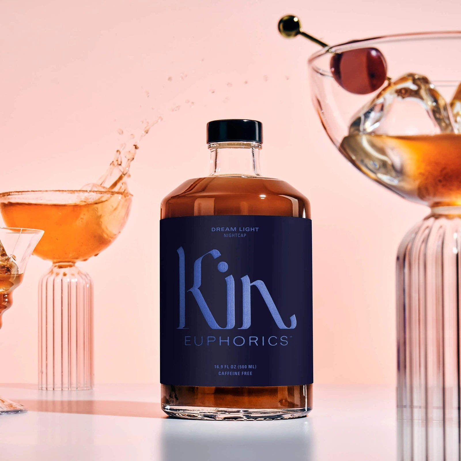 Dream Light with amber drinks and sculptural glassware on a blush studio set